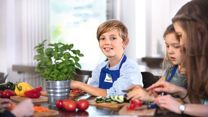 Kinder sind dabei Gemüse für das gemeinsame Mittagessen zu schneiden bei