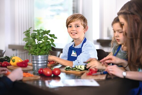 Kinder sind dabei Gemüse für das gemeinsame Mittagessen zu schneiden bei 