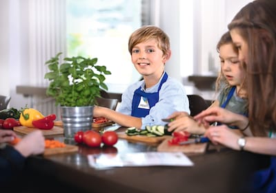 Kinder sind dabei Gemüse für das gemeinsame Mittagessen zu schneiden bei 