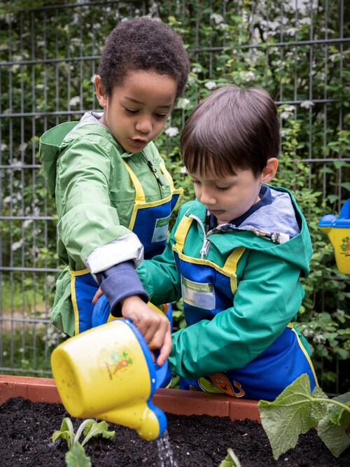 Kita-Kinder gießen bei 