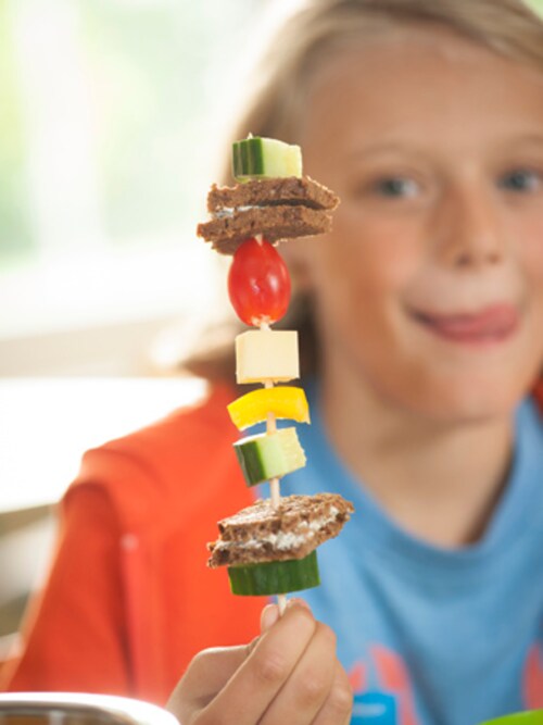 Ein Schüler hält zum Frühstück einen Piratenspieß hoch beim Projekttag 