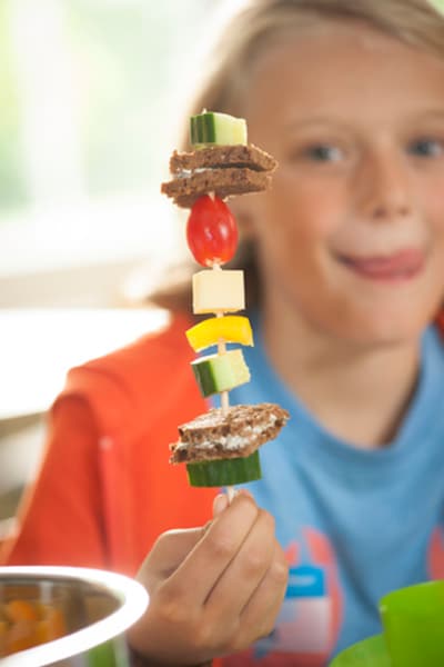 Ein Schüler hält zum Frühstück einen Piratenspieß hoch beim Projekttag 